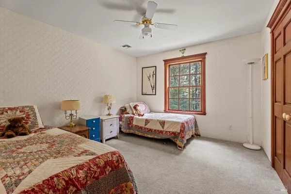 a bedroom with two beds and window