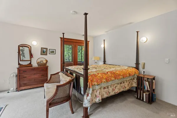 a bedroom with a bed a dresser next to a window