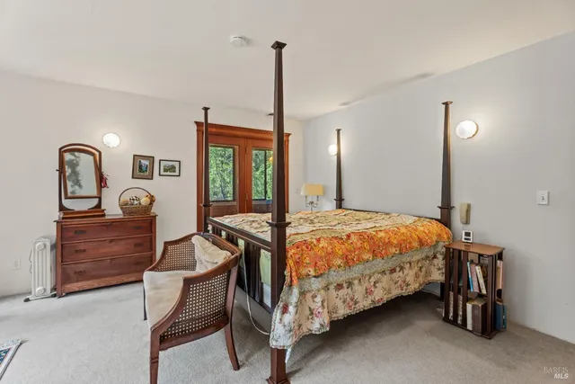 a bedroom with a bed a dresser next to a window