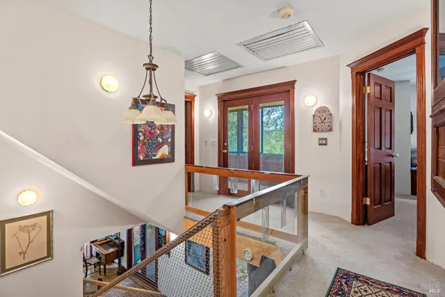 a view of a hallway with entryway and chandelier