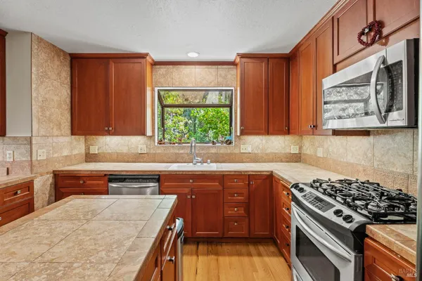a kitchen with stainless steel appliances a stove a sink and a microwave