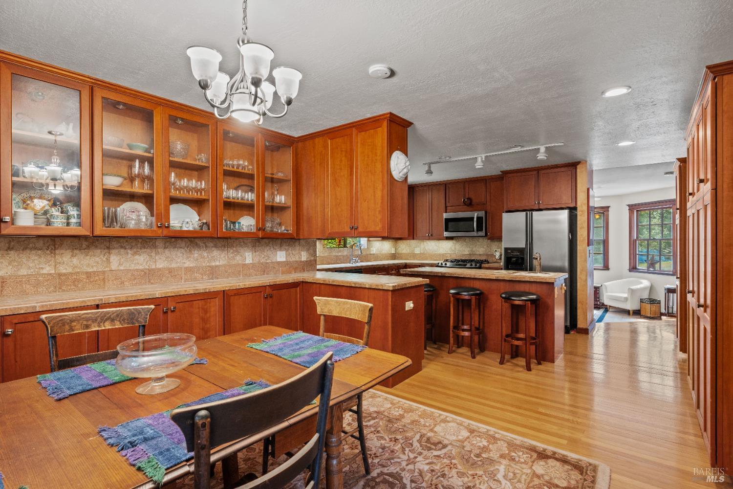 20475 Timber Road Willits, CA 95490 - Photo 9 of 38 a kitchen with a refrigerator a stove a sink and a dining table with wooden floor