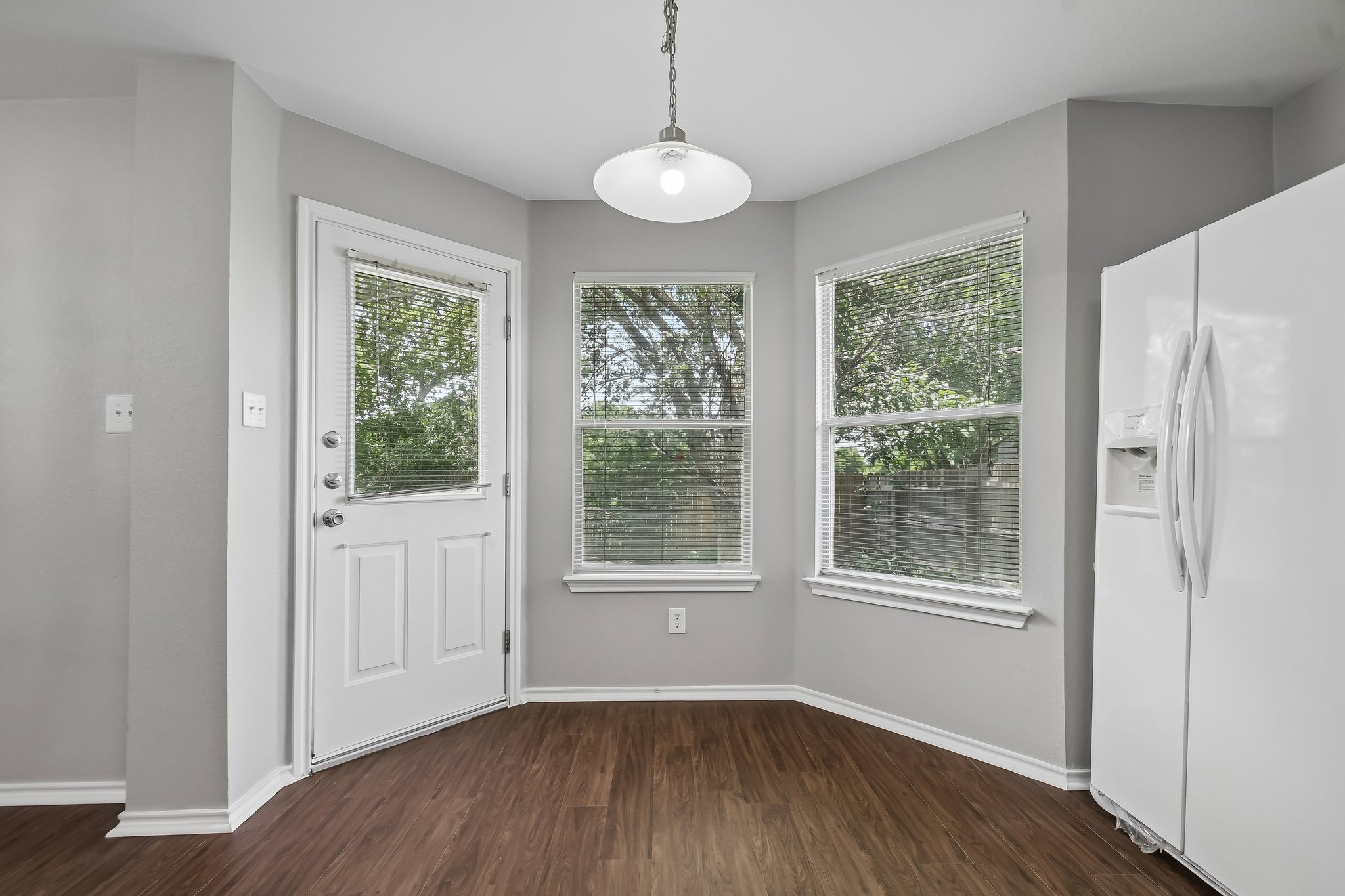 610 Lavaca Loop Elgin, TX 78621 - Photo 16 of 37 A corner dining nook with plentiful window light and rich wood flooring.