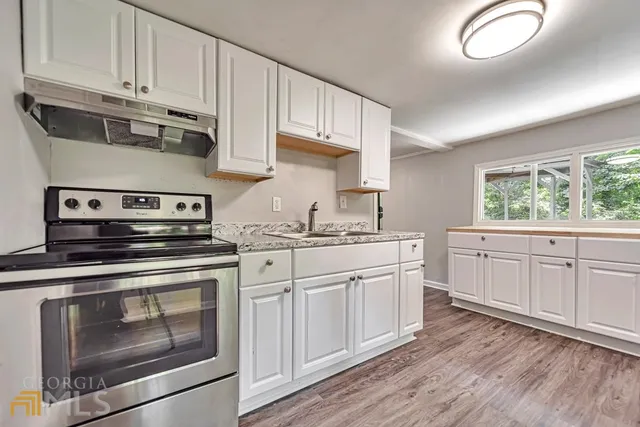 a kitchen with white cabinets stainless steel appliances and sink