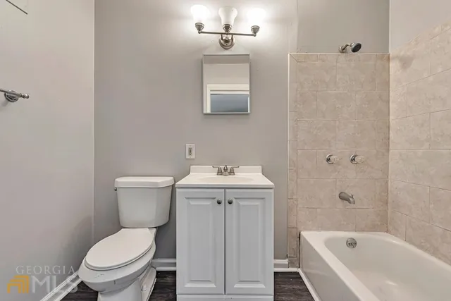 a white toilet sitting next to a bath tub