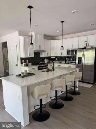 a kitchen with stainless steel appliances granite countertop a sink a stove and a refrigerator