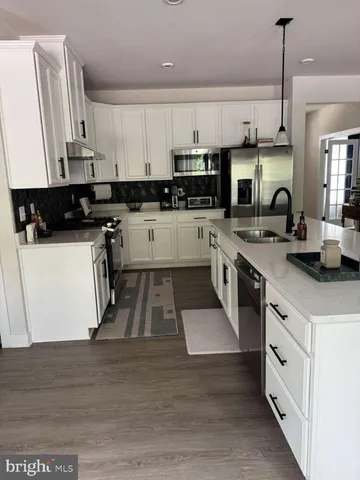 a kitchen with stainless steel appliances granite countertop a sink a stove and a refrigerator