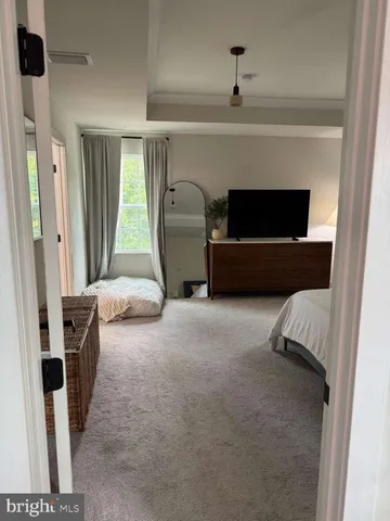 a bedroom with a bed couch and painting on the wall