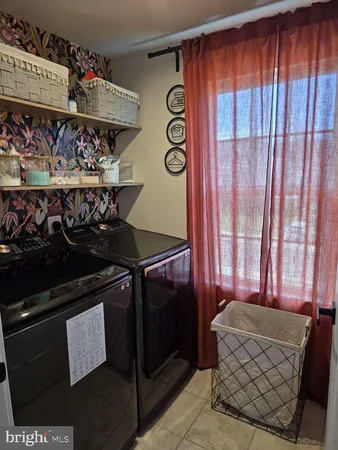 a view of an empty room with wooden cabinet and stairs