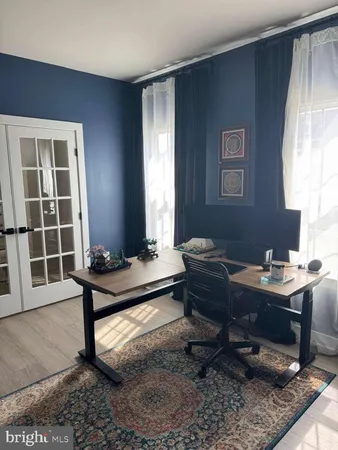 a view of a workspace with furniture and a window