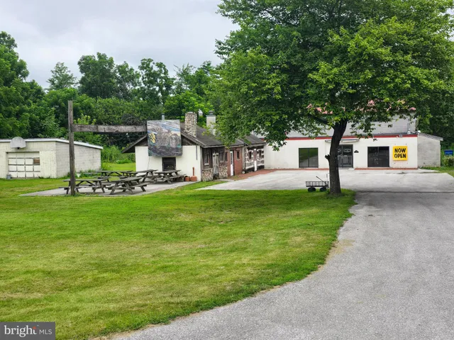 a front view of a house with a garden and trees