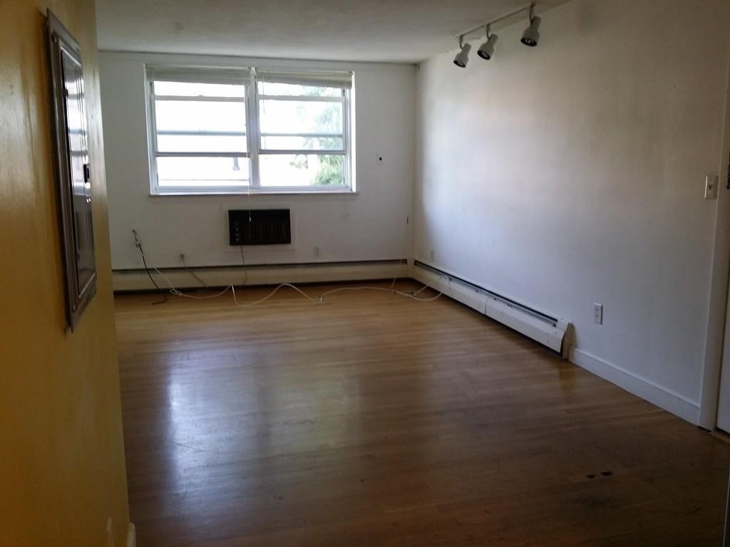 12 Commonwealth Court, Unit 15 Boston, MA 02135 - Photo 6 of 12 an empty room with a fireplace and windows