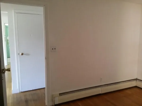 a view of an empty room with wooden floor
