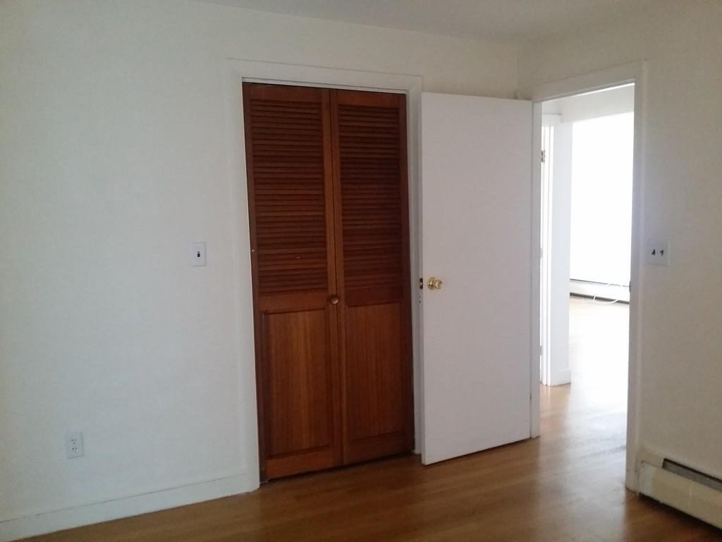 12 Commonwealth Court, Unit 15 Boston, MA 02135 - Photo 8 of 12 a view of an empty room with wooden floor