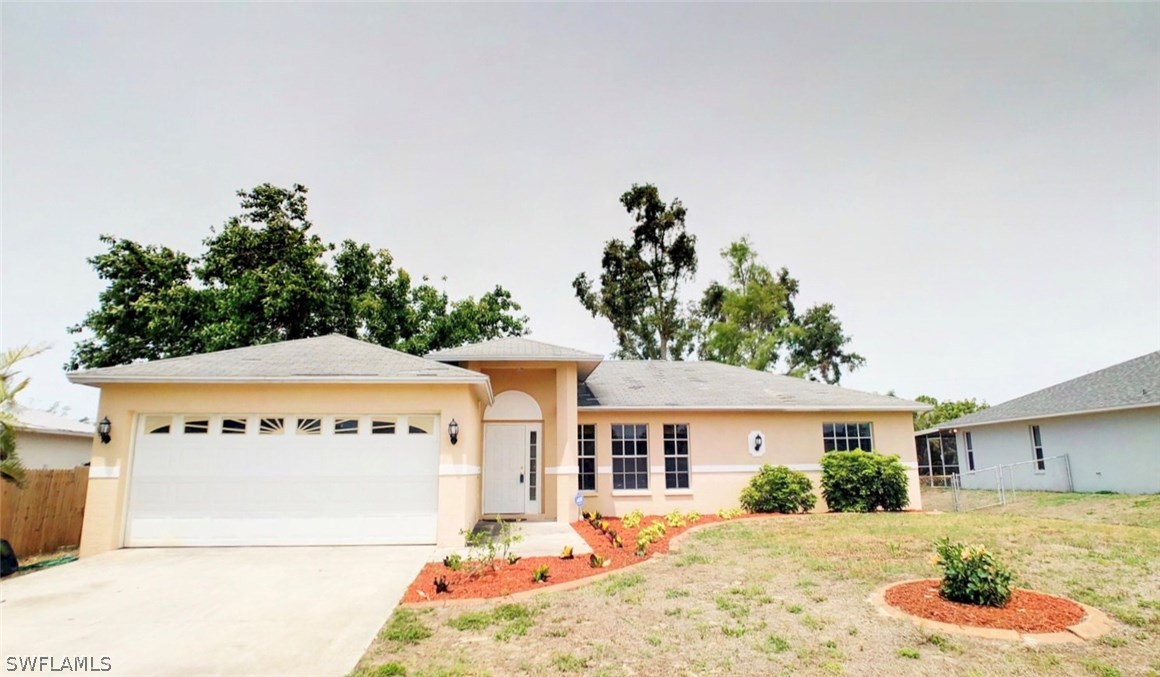 17424 Delaware Road Fort Myers, FL 33967 - Photo 1 of 12 a front view of a house with a yard and potted plants
