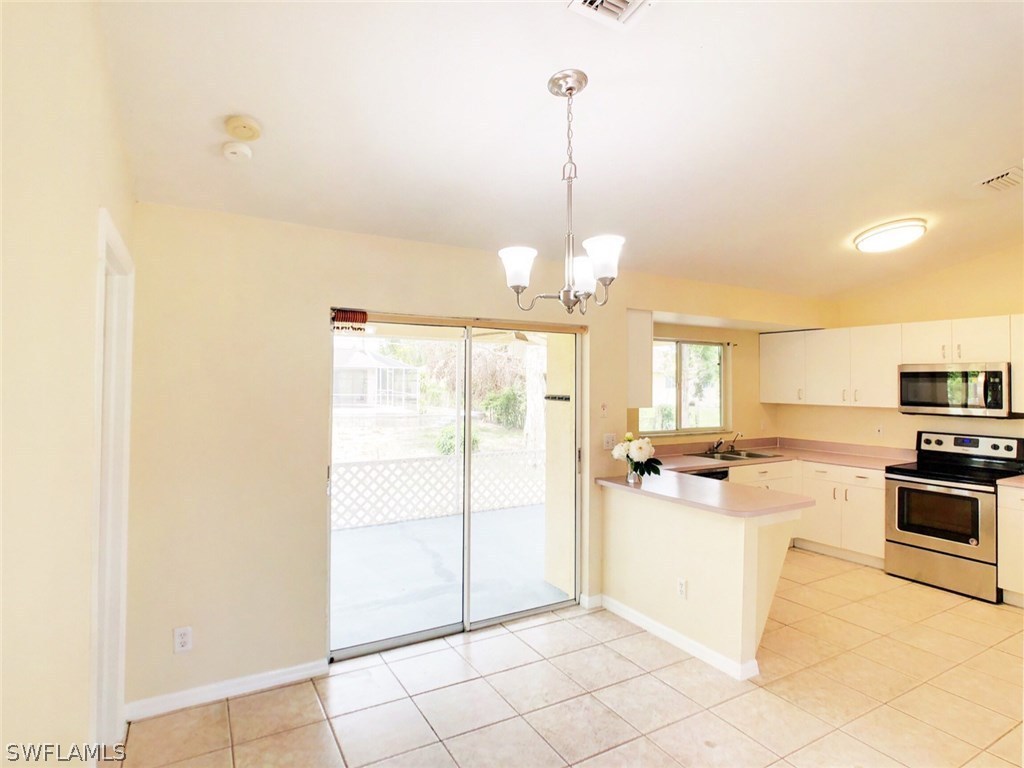 17424 Delaware Road Fort Myers, FL 33967 - Photo 4 of 12 a kitchen with kitchen island a counter top space appliances and cabinets