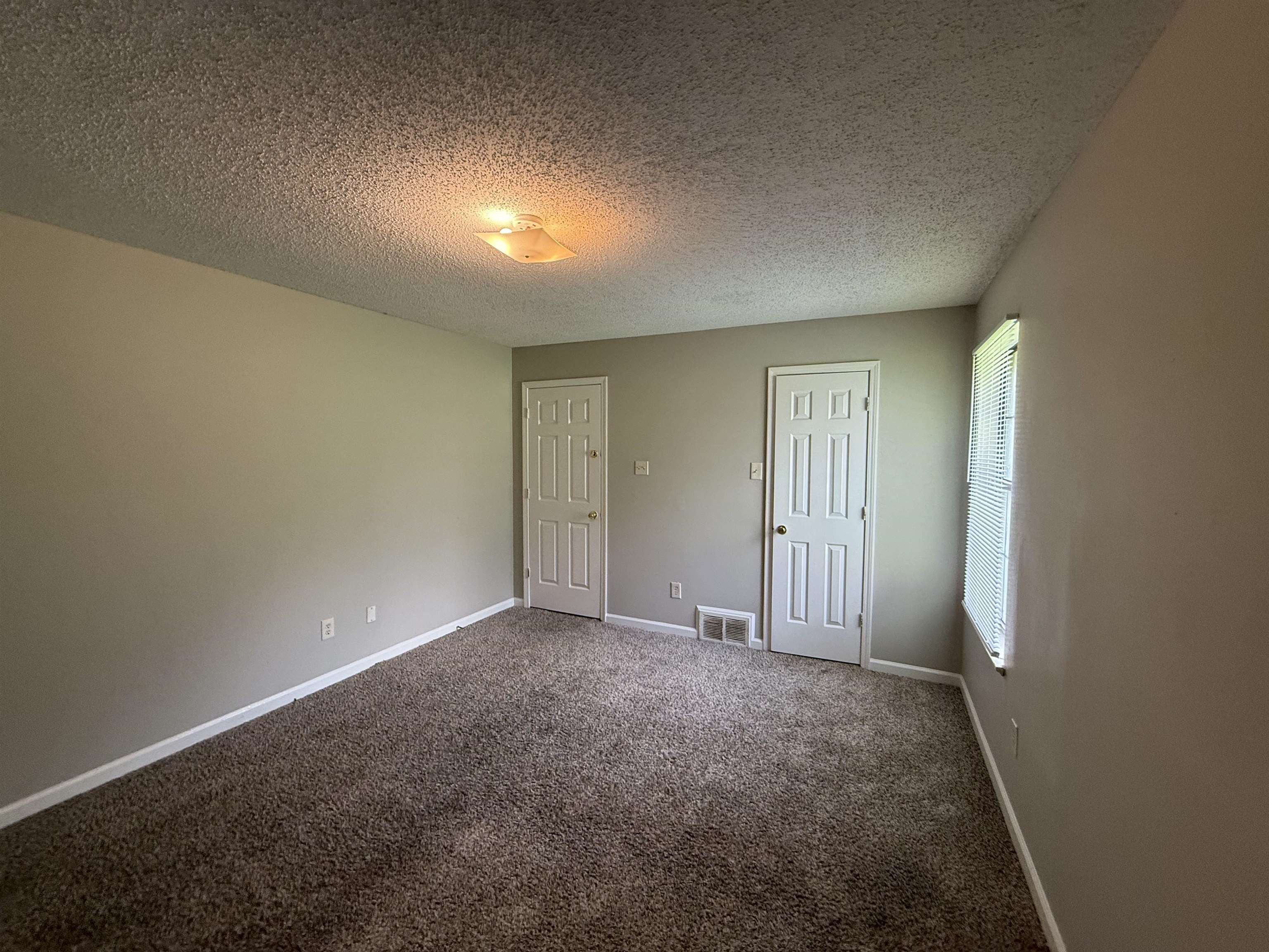 6420 Saginaw Road Memphis, TN 38134 - Photo 31 of 38 Spacious interior room with neutral-toned walls, brown textured carpeting, and white baseboards