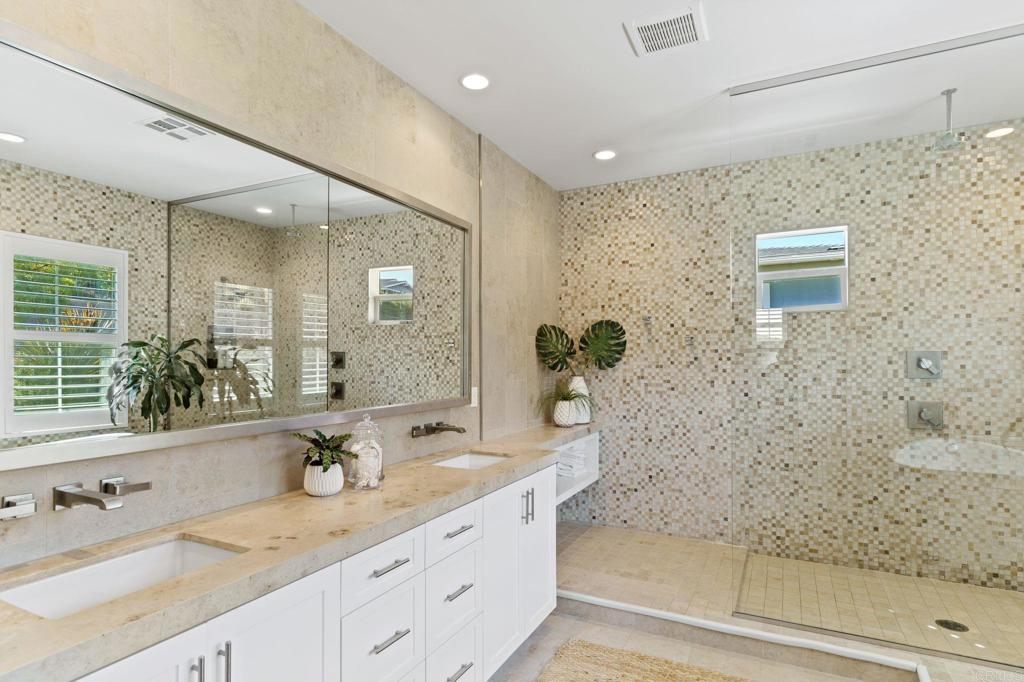 663 Polaris Drive Encinitas, CA 92024 - Photo 17 of 34 a bathroom with a granite countertop sink a mirror and a shower