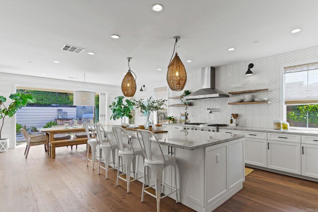 663 Polaris Drive Encinitas, CA 92024 - Photo 4 of 34 a kitchen with stainless steel appliances granite countertop a stove a sink dishwasher and white countertops with wooden floor