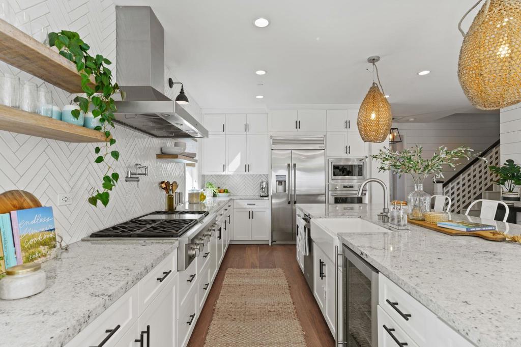 663 Polaris Drive Encinitas, CA 92024 - Photo 7 of 34 a kitchen with stainless steel appliances granite countertop a sink a stove and a wooden floors