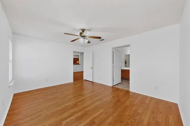 a view of an empty room with a window and a ceiling fan