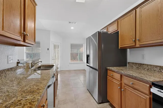 a kitchen with granite countertop a sink and a stove top oven
