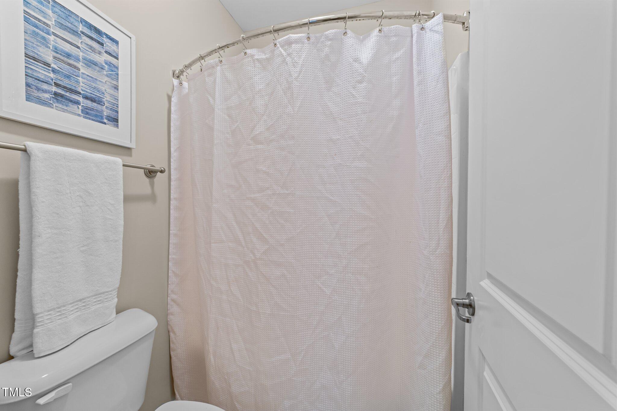 5644 Wade Park Boulevard Raleigh, NC 27607 - Photo 22 of 29 a bathroom with a shower curtain and a toilet