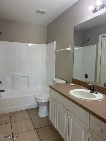 a bathroom with a granite countertop sink a toilet and a bathtub