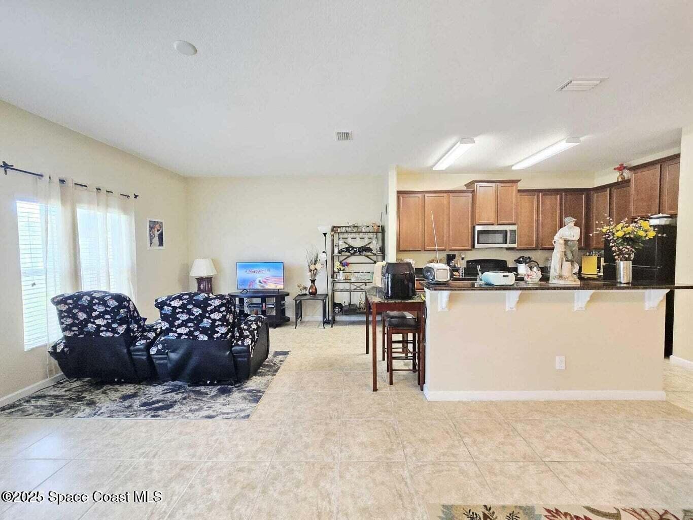 2735 Revolution Street, Unit 101 Melbourne, FL 32935 - Photo 12 of 24 a large kitchen with a table and chairs
