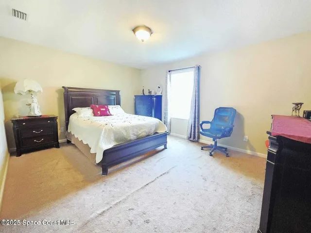 a bedroom with a bed a table and lamp