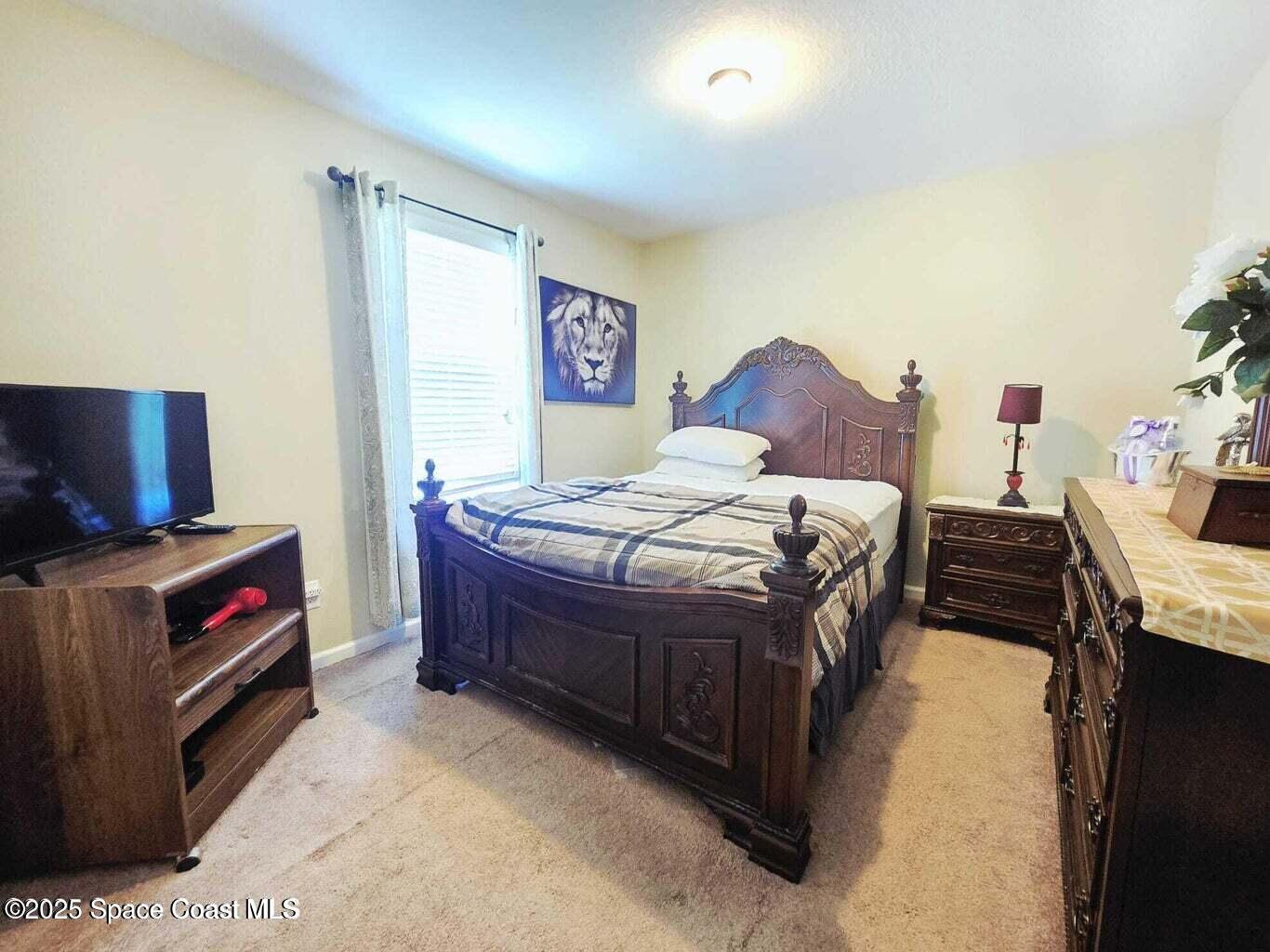 2735 Revolution Street, Unit 101 Melbourne, FL 32935 - Photo 16 of 24 a bedroom with a bed and a tv