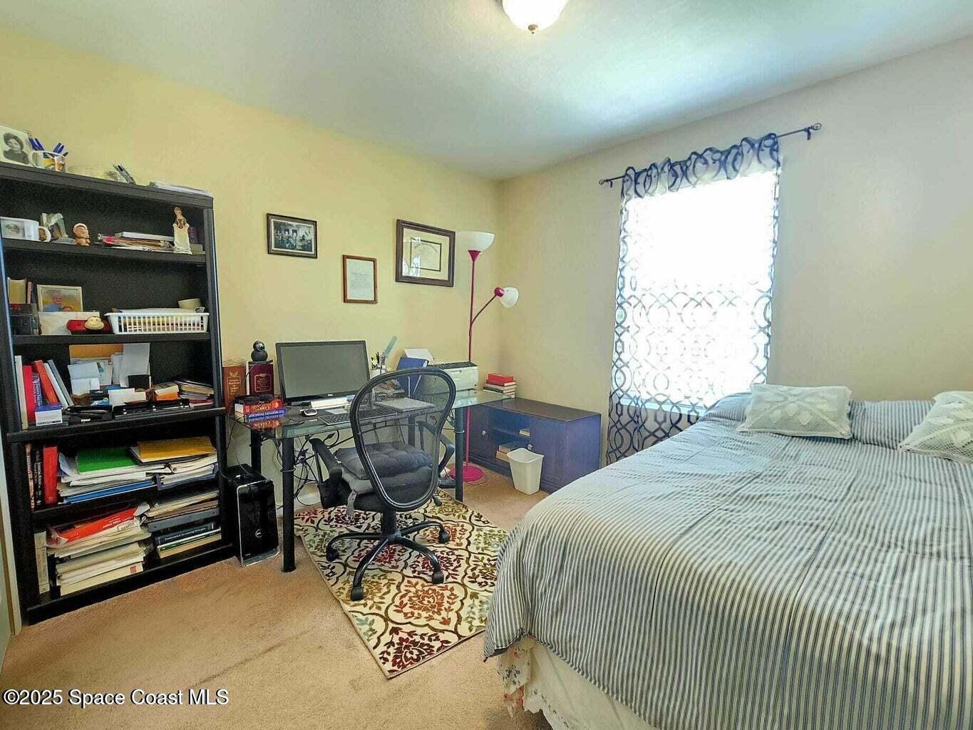 2735 Revolution Street, Unit 101 Melbourne, FL 32935 - Photo 17 of 24 a bedroom with a bed a dresser and a large window