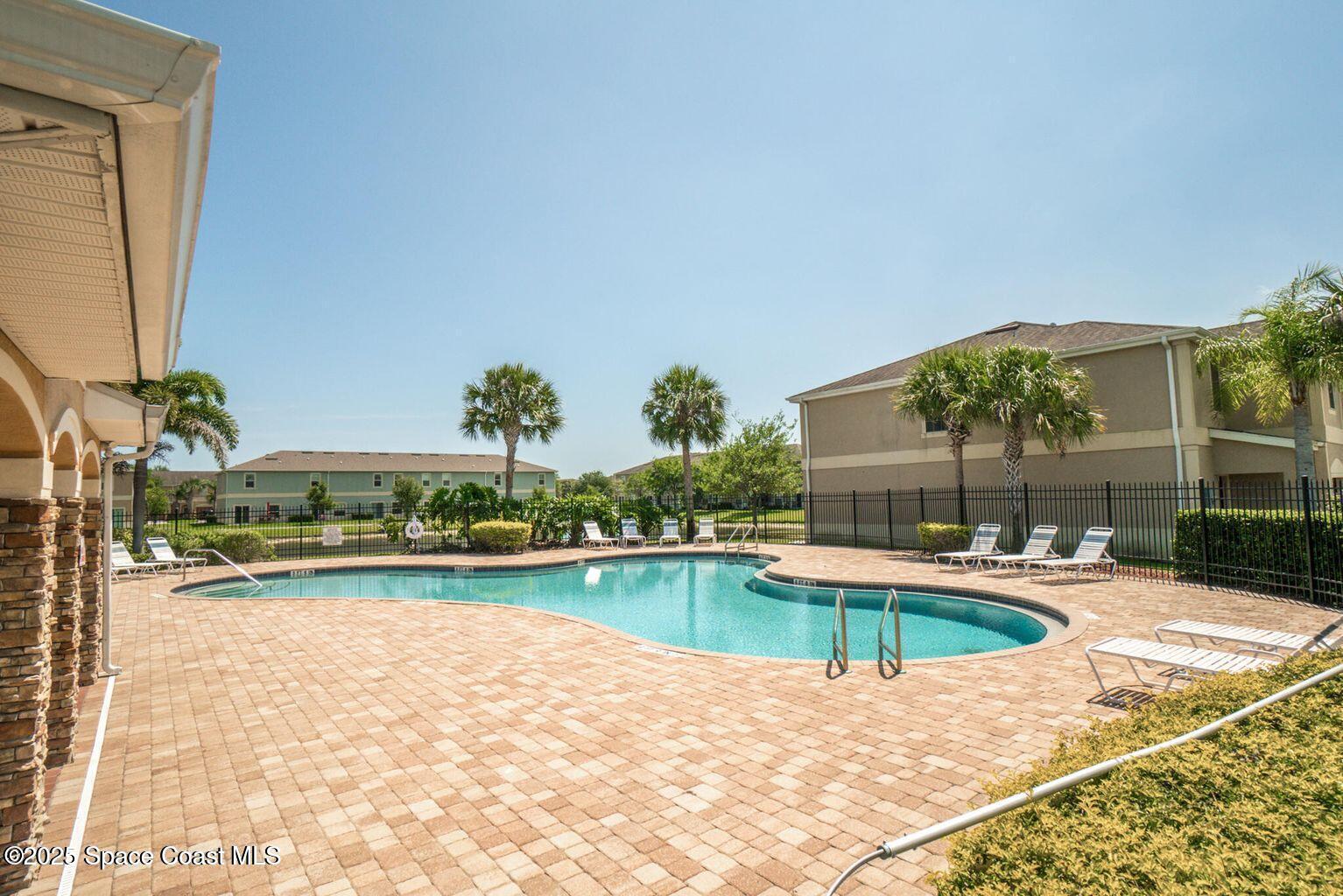 2735 Revolution Street, Unit 101 Melbourne, FL 32935 - Photo 21 of 24 a swimming pool with outdoor seating and yard