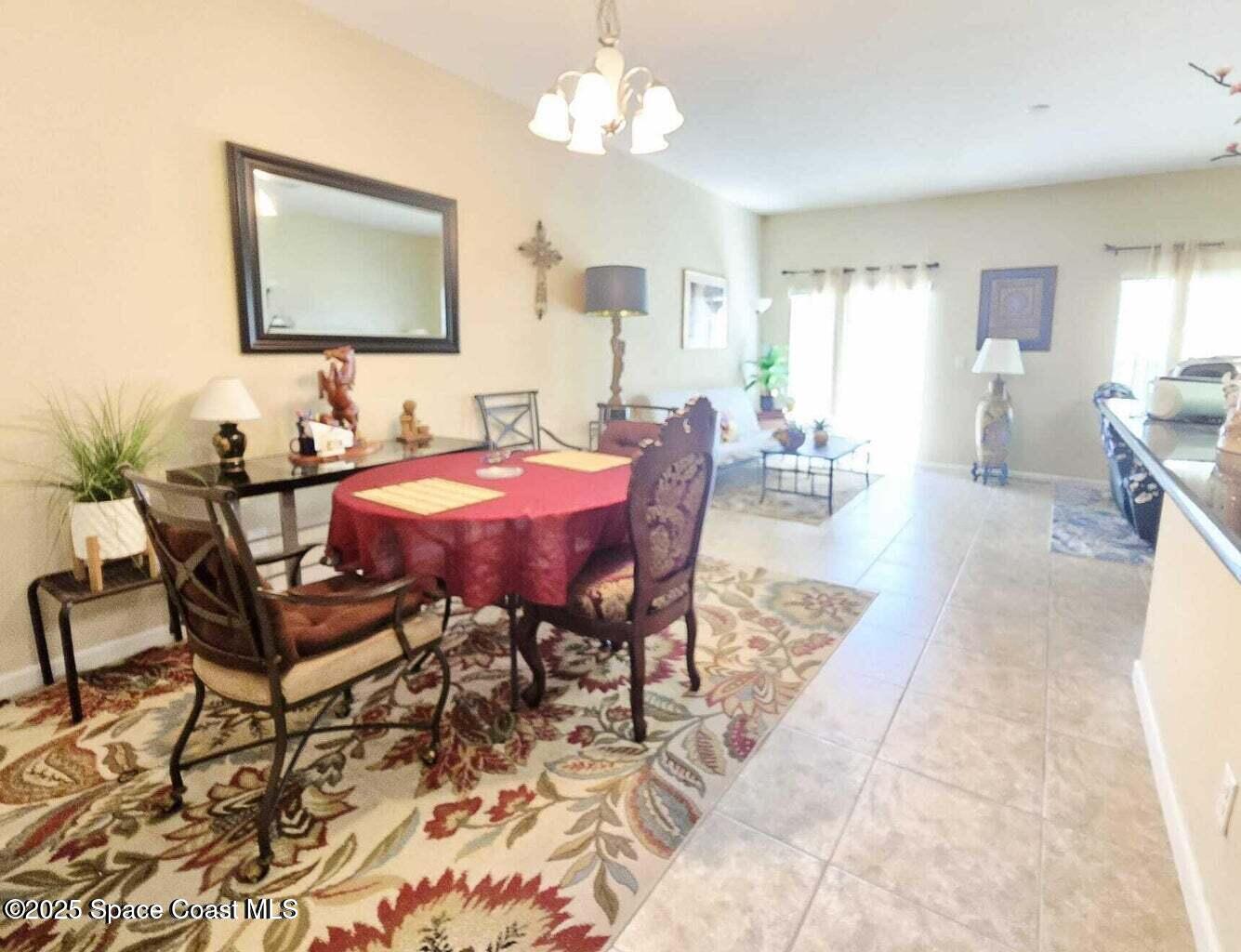 2735 Revolution Street, Unit 101 Melbourne, FL 32935 - Photo 8 of 24 a view of a dining room with furniture and chandelier