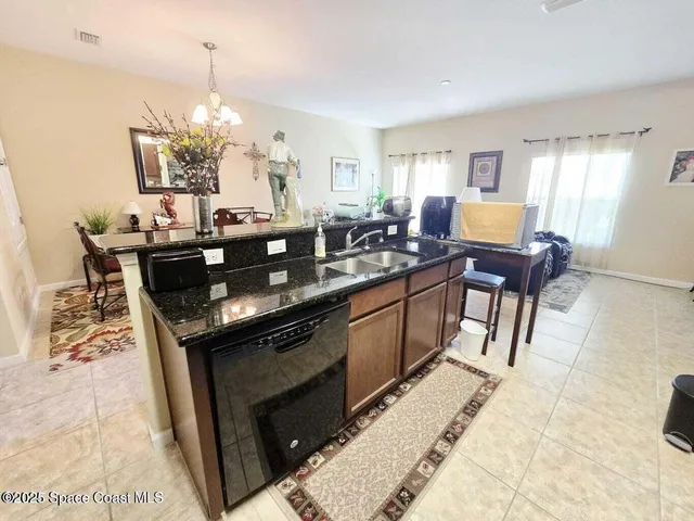 a kitchen with granite countertop a sink dining table and chairs
