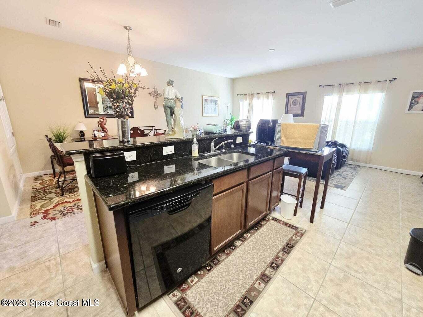 2735 Revolution Street, Unit 101 Melbourne, FL 32935 - Photo 9 of 24 a kitchen with granite countertop a sink dining table and chairs