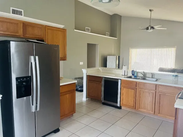 a large kitchen with a refrigerator and a sink