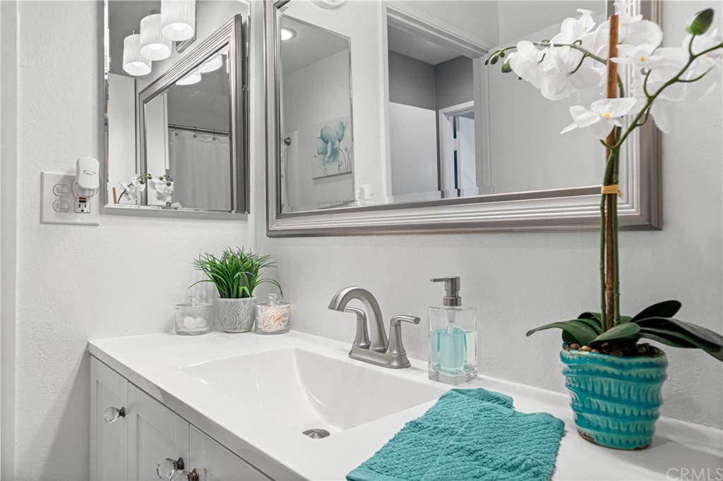1040 West MacArthur Boulevard, Unit 104 Santa Ana, CA 92707 - Photo 14 of 30 a bathroom with a sink a potted plant and a mirror
