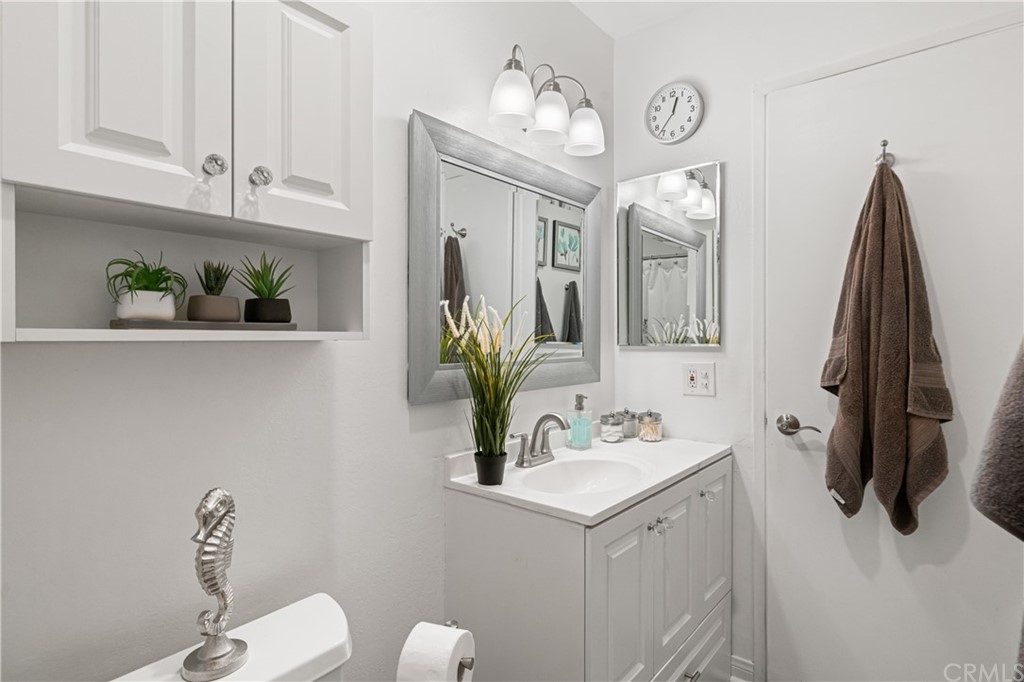 1040 West MacArthur Boulevard, Unit 104 Santa Ana, CA 92707 - Photo 22 of 30 a bathroom with a sink a toilet and mirror