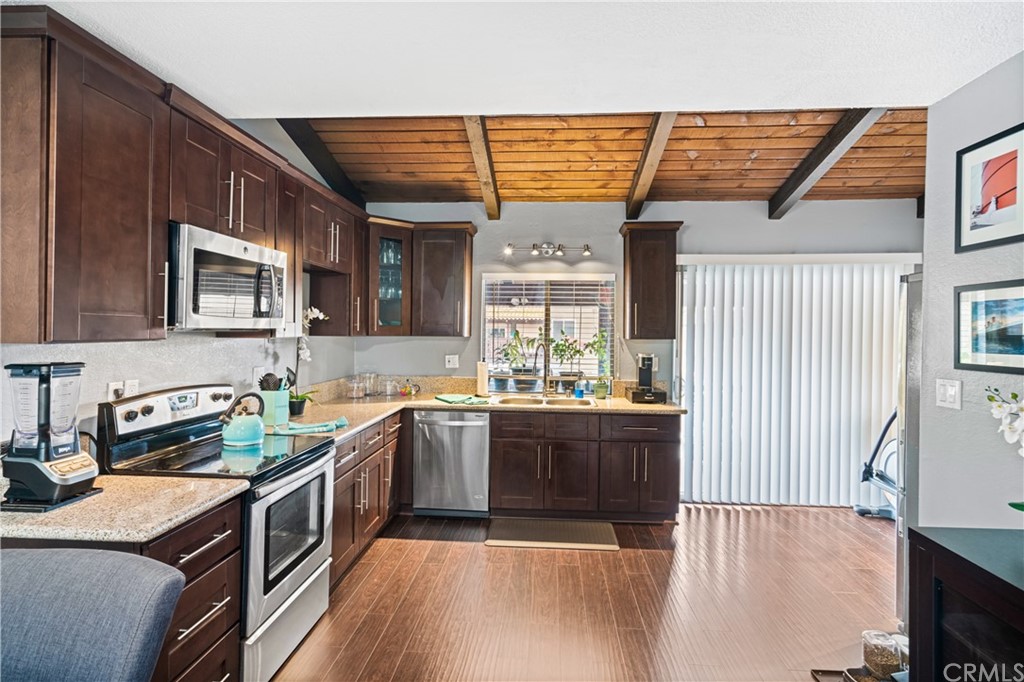 1040 West MacArthur Boulevard, Unit 104 Santa Ana, CA 92707 - Photo 7 of 30 a kitchen with stainless steel appliances granite countertop a sink stove and cabinets