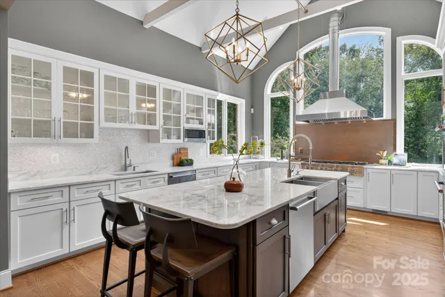 a kitchen with a stove a sink dishwasher a dining table and chairs