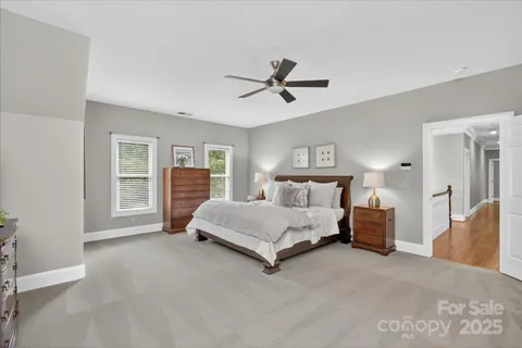 a spacious bedroom with a bed and lamp