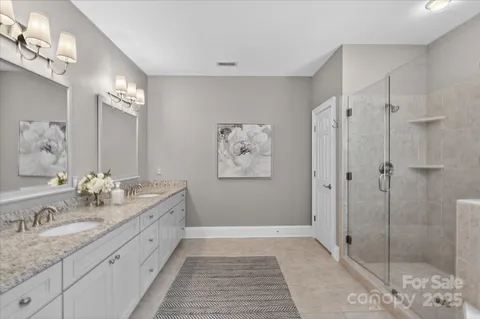a spacious bathroom with a granite countertop sink mirror and shower
