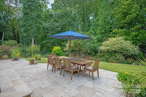 a view of a table and chairs under an umbrella in backyard