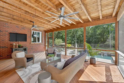 a living room with patio furniture and a flat screen tv