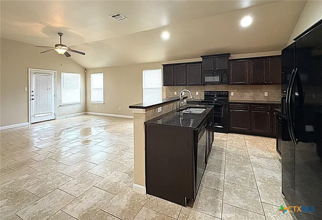 a kitchen with stainless steel appliances granite countertop a stove a sink and a refrigerator