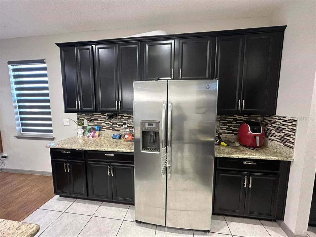 3100 Rocky River Road Kissimmee, FL 34746 - Photo 15 of 33 a kitchen with stainless steel appliances granite countertop a refrigerator and a sink