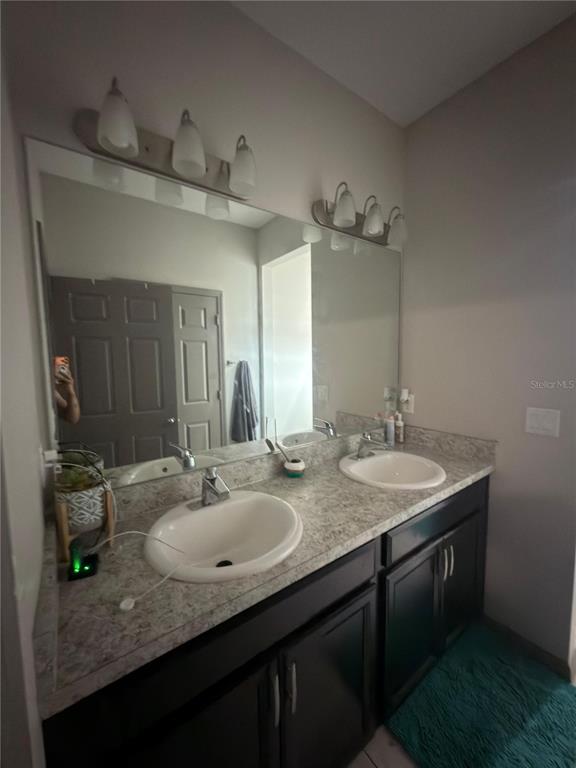 3100 Rocky River Road Kissimmee, FL 34746 - Photo 28 of 33 a bathroom with a granite countertop sink and a mirror