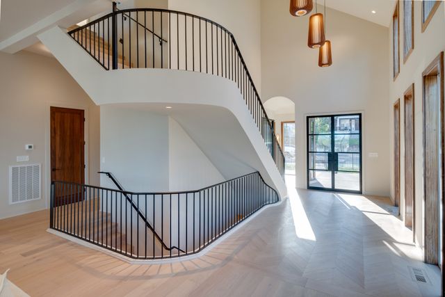 a view of staircase with railing and white walls