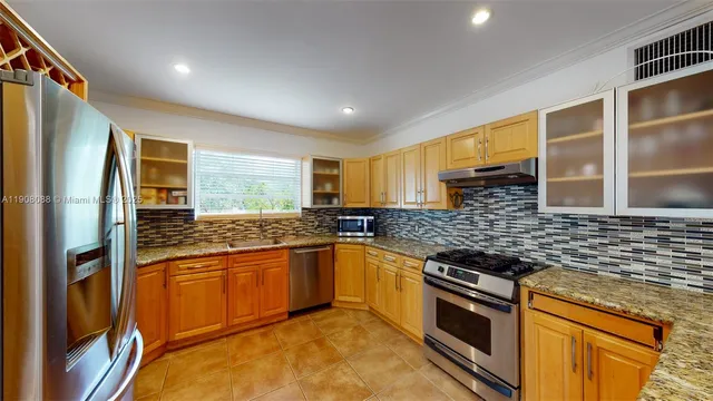 a kitchen with stainless steel appliances granite countertop a stove and a refrigerator